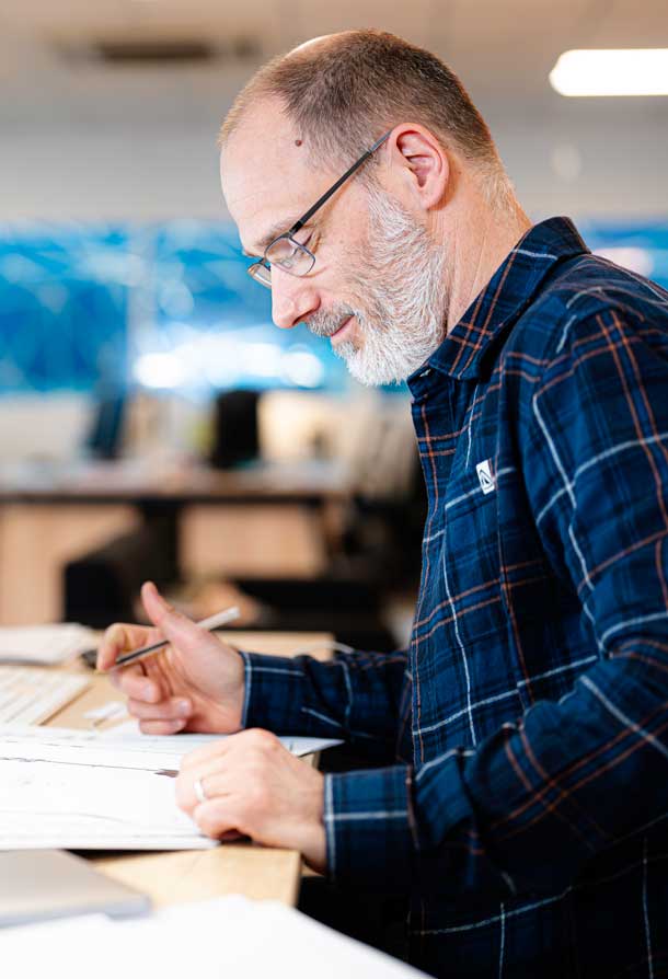 Un commercial travaille a son bureau sur un devis Alternative text - Un commercial travaille a son bureau sur un devis